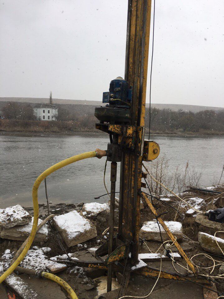 Буровая установка на берегу канала во время бурения скважины